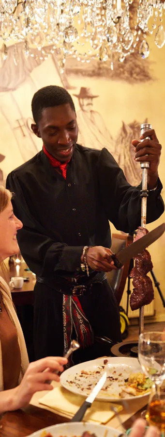 Een gaucho snijdt vlees aan tafel