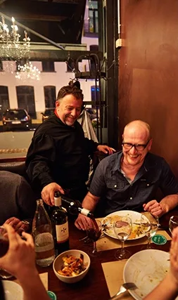 Gasten aan tafel terwijl de wijn wordt ingeschonken